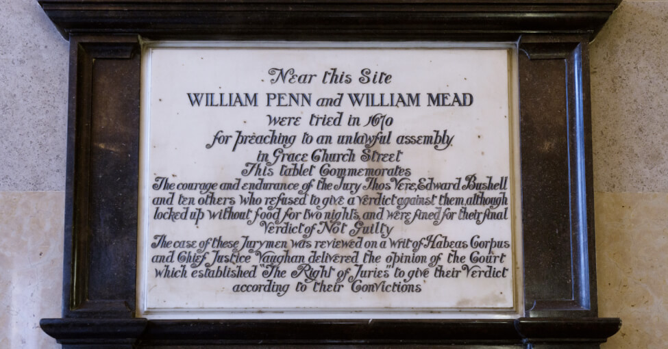 Photograph of a plaque in the Old Bailey reading: 'Near this site William Penn and William Mead were tried in 1670 for preaching to an unlawful assembly in Grace Church Street. This tablet commemorates the courage and endurance of the jury Thos Vere, Edward Bushell and ten others who refused to give a verdict against them although locked up without food for two nights and were fined for their final verdict of not guilty. The cause of these jurymen was reviewed on a writ of Habeus Corpus and Chief Justice Vaughan delivered the opinion of the court which established 'The right of juries' to give their verdict according to their convictions'